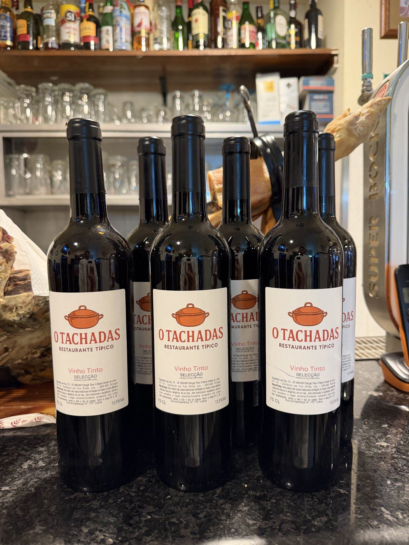 As garrafas do vinho da casa O Tachadas, ao balcão na Rua da Esperança